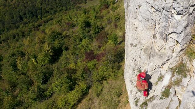  Flying near a mountain rescuer rappelling on a rocky wall with a drone