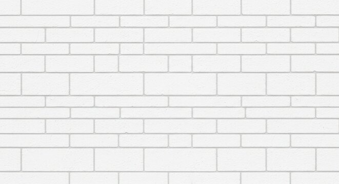 A white brick wall with varying brick lengths creates a textured and patterned surface.