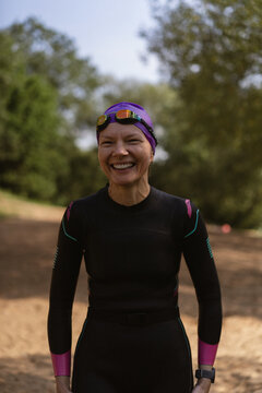 Smiling woman in a wetsuit preparing for water sports outdoor
