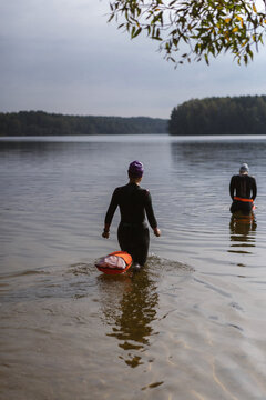 Two women prepare for an open water swim in a lake
