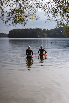 Two women prepare for an open water swim in a lake