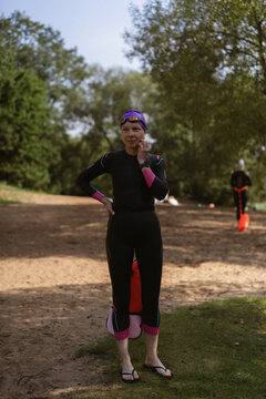 Smiling woman in a wetsuit preparing for water sports outdoor