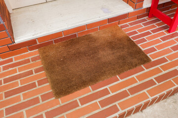 Welcome mat on red brick floor,Overhead of blank doormat at the front door,office or home,space for text.