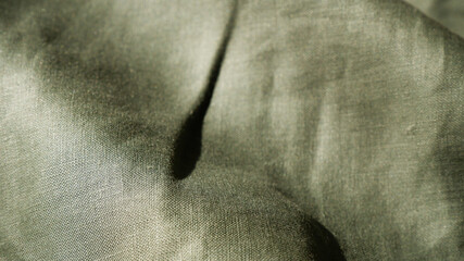 Fototapeta premium Dark green linen texture with soft blurred background. Texture background of close-up linen fabric. Abstract, vintage cloth, fashion, blurry for wallpaper, print, textile. Olive green clothing surface