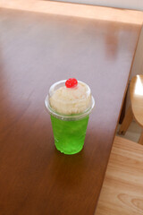 Melon soda float with vanilla ice cream and cherry on top in summer time,Melon soda is one of the most popular Japanese drink,Japanese cafe menu.