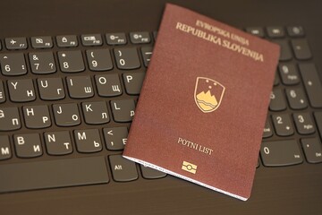 Slovenia passport lies on black laptop keyboard buttons background . Technologies in Europe