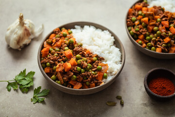 Assiette de ragout de viande hachée et petits pois carottes accompagnée de riz blanc