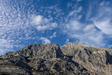 Gray rocks with small vegetation against the sky. Mountain landscape, Croatia. copy space