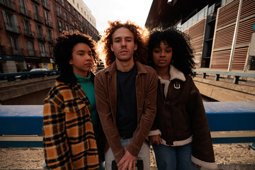 Three young artists posing in the city at sunset