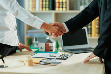 A house seller shakes hands with a new homeowner.
