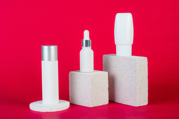 Cosmetic product in tube, bottle, lotion or serum with stylish props on red background. 