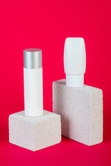 Cosmetic product in tube, bottle, lotion or serum with stylish props on red background. 