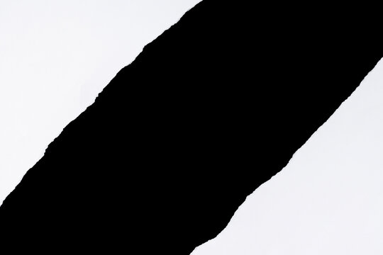 Torn white paper with center diagonal rip on black background.