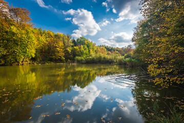 Autumn colorful foliage over lake with beautiful woods in red and yellow color. Bakony Forest and Mountain, Pisztrangos Lake, Hungary