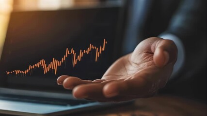 Man’s hand holding digital financial graph. Businessman analyzing stock market data with rising trend on laptop screen for investment success. footage - Powered by Adobe