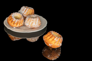 Sweet homemade cupcakes isolated on black background, close-up.