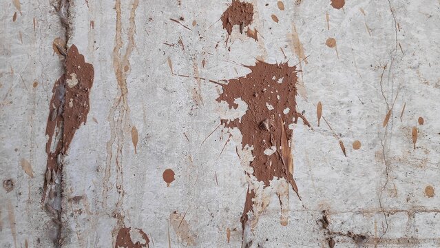 Old weathered wall shows brown paint splatters and cracks creating abstract texture on concrete surface, evoking sense of decay and urban grunge. - Powered by Adobe