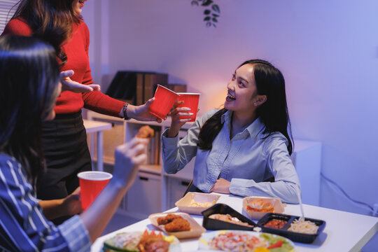 Young friends celebrating with food and drinks at night party