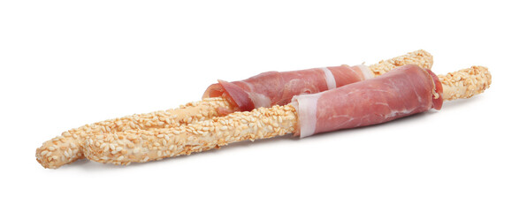 Delicious grissini sticks with sesame seeds and prosciutto isolated on white