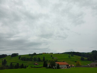 landscape of a green field with clouds in Switzerland