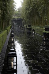A serene, rain-drenched pathway lined with black lanterns and bordered by lush greenery, leading through a tranquil bamboo grove.