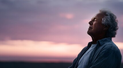 Elderly man with eyes closed embracing a peaceful moment against a serene twilight sky
