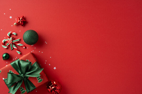 Vivid holiday scene featuring wrapped gifts, ornaments, and candy canes on a red backdrop, capturing festive mood, joy, and celebration for Christmas and New Year greetings - Powered by Adobe