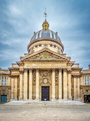 Obraz premium Institut de France in Paris, France, with its grand neoclassical dome, Corinthian columns, and ornate facade under a cloudy sky, an iconic French architectural landmark.