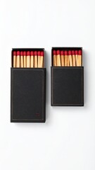 Two black matchboxes, one large and one small, filled with wooden matches with red heads, on a white background