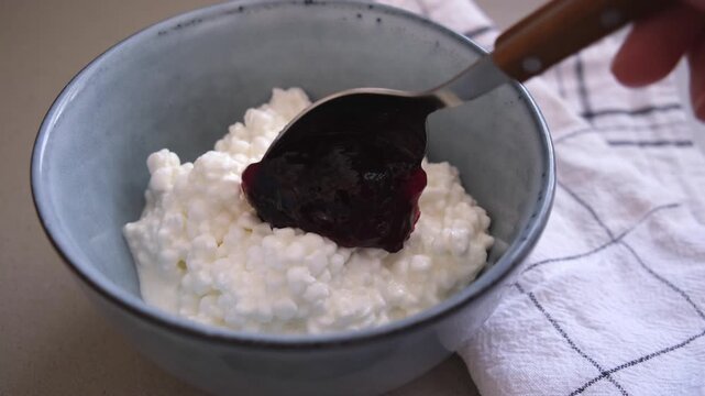 Making cottage cheese with berry jam. Protein fitness breakfast concept.