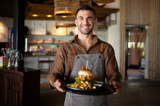 Restaurant marketing moment, a fresh burger and fries served with a smile creates visual content - Powered by Adobe