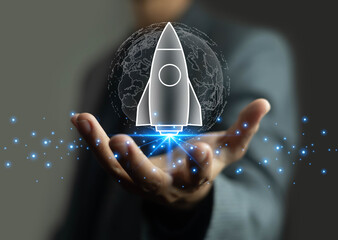Businessman hand holding digital rocket with glowing world map background, symbolizing global startup, innovation, business growth, technology development, and future entrepreneurship success concept.