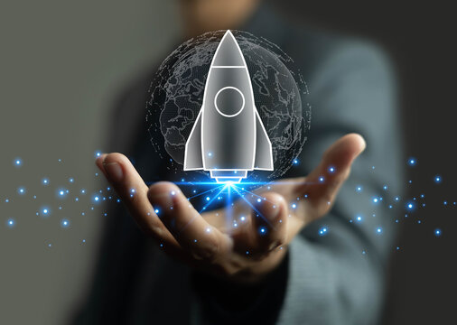 Businessman hand holding digital rocket with glowing world map background, symbolizing global startup, innovation, business growth, technology development, and future entrepreneurship success concept.