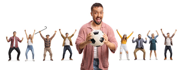 Excited man holding a football in front of a group of fans cheering