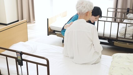Fototapeta premium 高齢者の体位変換を行うアジア人介護士
