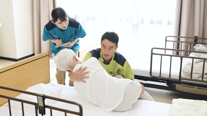 体位変換の指導を行うアジア人介護士