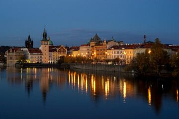 Prague historic centre blue hour cityscape with lights mirroring in river, Prague, Czechia