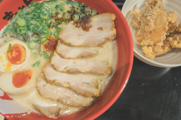 Japanese ramen with rich broth, sliced pork chashu, soft-boiled egg, scallion, and spicy sauce, served with side karaage fried chicken. Authentic Japanese comfort food and restaurant favorite.