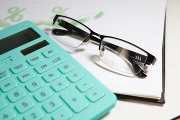 calculator and glasses on a white background, business still life