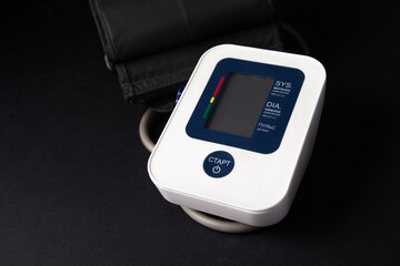 Digital blood pressure monitor on black background. Healthcare and medical concept.