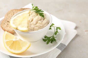 Tasty horseradish sauce with parsley and lemon slices served on light table, closeup