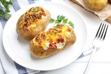 Tasty stuffed baked potatoes served on white wooden table, closeup