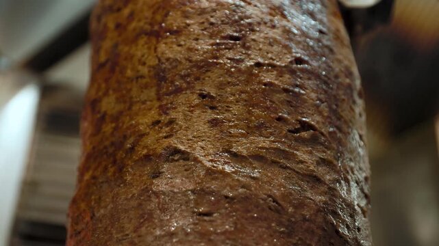 Close-up of a doner kebab sizzling on a rotating skewer, perfect for street food, restaurant, and culinary preparation visuals.