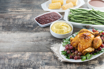 Thanksgiving roasted turkey with mashed potatoes, cranberry sauce and green beans on rustic wooden table. Copy space