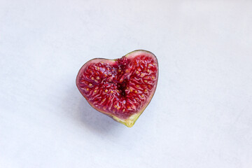 Ripe figs in the shape of a heart. The concept is a healthy diet, vegetarianism, and a Mediterranean diet.