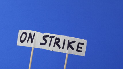 Strike written on a protest sign with a blue background.