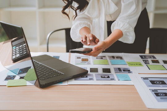 Web designer using smartphone for app development prototype - Powered by Adobe