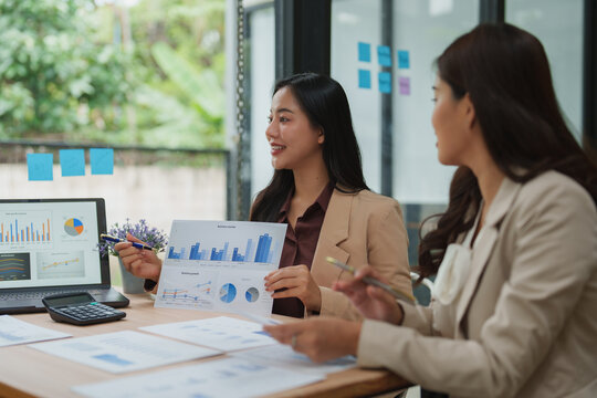 Businesswomen discussing financial charts and graphs in office meeting