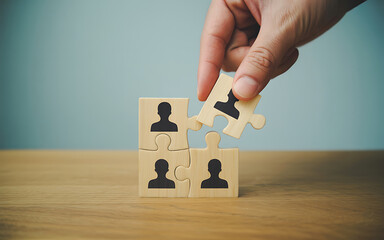 Hand placing a puzzle piece with a person silhouette into a grid of people