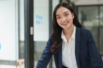 Young asian businesswoman smiling in modern office environment